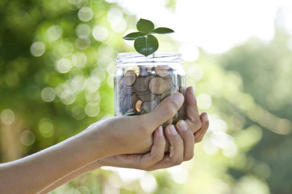 Hands holding money in a jar