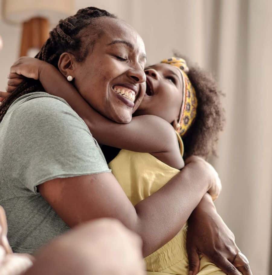 Women smiling and hugging child