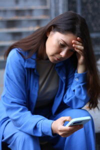 sad woman holding her head while talking on the phone, receiving bad news