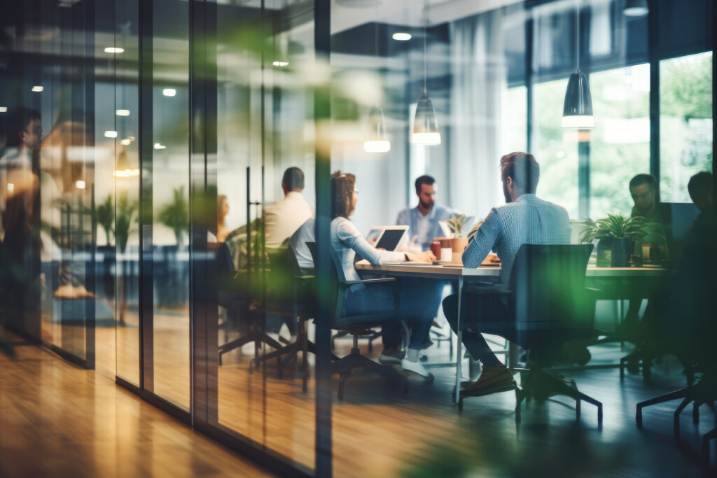 Office photo of employees sitting at a conference table.
