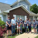 a group of people smiling in front of a house