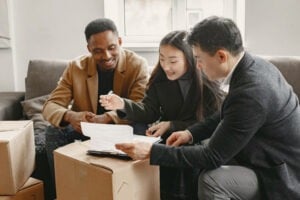Young Couple Buying A New House. Asian woman and African man. Signing documents at new home.
