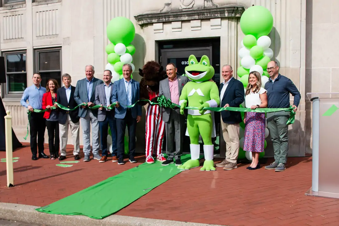 Group of people standing in front of a new building for a ribbon cutting ceremony