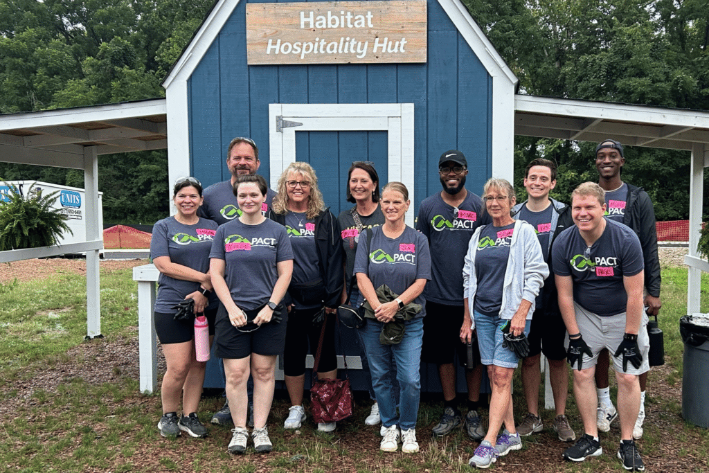 Group of Merchants Bank employees standing in front of a barn after a volunteer event.