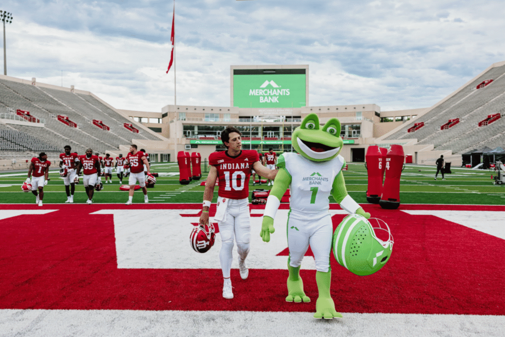 IU Football's Quarterback, Josh Hoover walking with Merchants Bank Mascot, Hopper