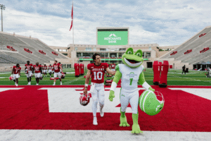 IU Football's Quarterback, Josh Hoover walking with Merchants Bank Mascot, Hopper